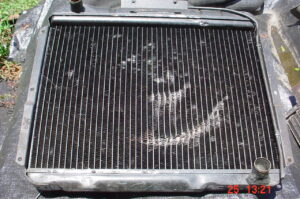 Engine side photo of the radiator showing damage cause by the cooling fan blades striking the radiator core.